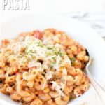 Creamy Cheesy Lentil Pasta is vibrant and delicious. This photo shows the finished product topped with cheese and dried herbs. Text overlay reads, "Cheesy Lentil Pasta".