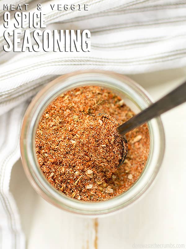 Chicken seasoning in a glass jar with a spoon in it. Text overlay reads, "Meat & Veggie 9 Spice Seasoning".