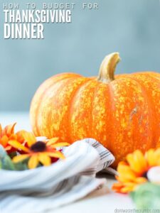 Image of pumpkin and flowers. Learn how to host thanksgiving on a budget. Text overlay reads, "How to Budget for Thanksgiving Dinner"